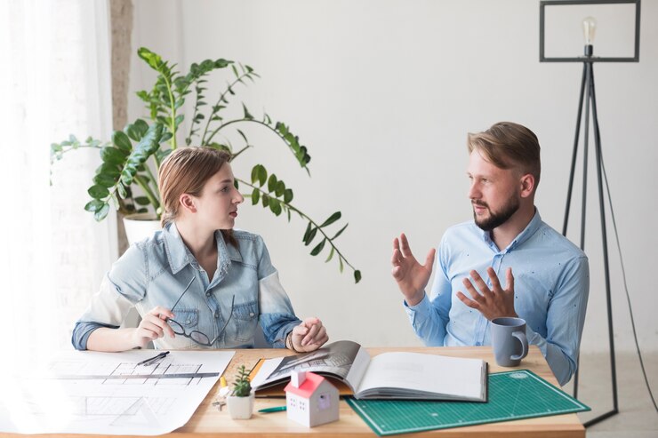 Kostenlose Foto zwei junge kollegen, die etwas im büro besprechen