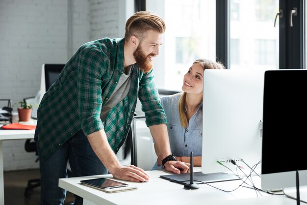 Zwei junge konzentrierte Kollegen arbeiten im Büro