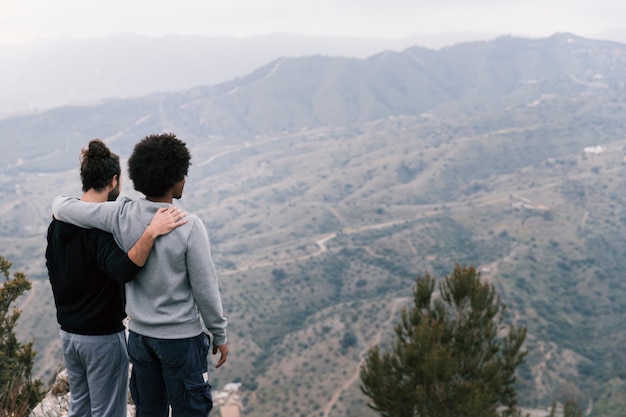 Zwei junge Männer, die über die Berglandschaft schauen