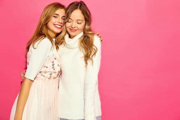 Zwei junge schöne lächelnde frauen in den trendigen weißen sommerkleidern
