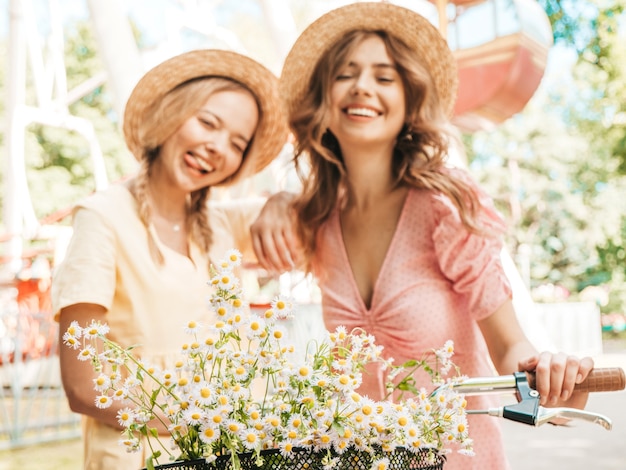 Zwei junge schöne lächelnde Hippie-Frau im trendigen Sommerkleid