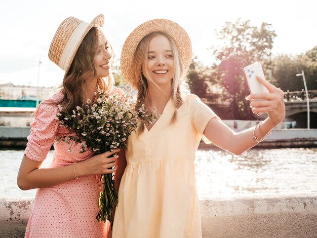 Zwei junge schöne lächelnde Hippie-Frau im trendigen Sommerkleid