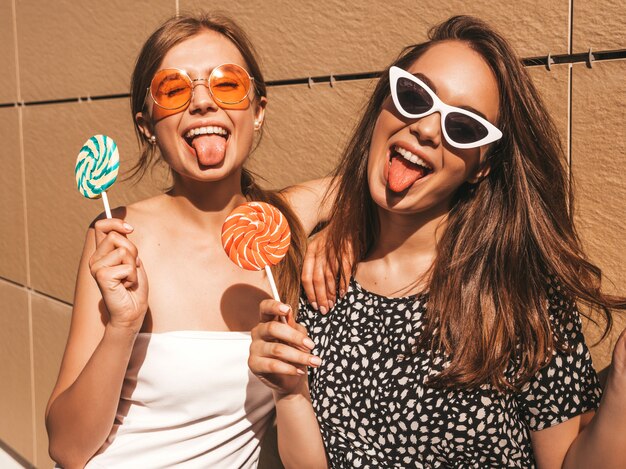 Zwei junge schöne lächelnde Hippie-Mädchen im modischen Sommerkleid.
