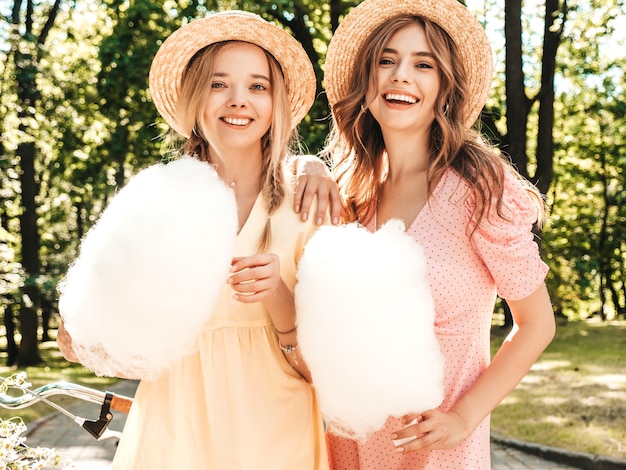 Zwei junge schöne lächelnde Hippie-Mädchen im trendigen Sommerkleid