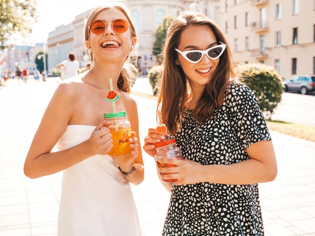 Zwei junge schöne lächelnde Hippie-Mädchen in der modischen Sommerkleidung