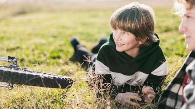 Zwei Jungen, die auf Gras ruhen, während sie ihre Fahrräder fahren