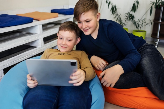 Zwei Jungen, die ein Tablet verwenden und zusammenarbeiten