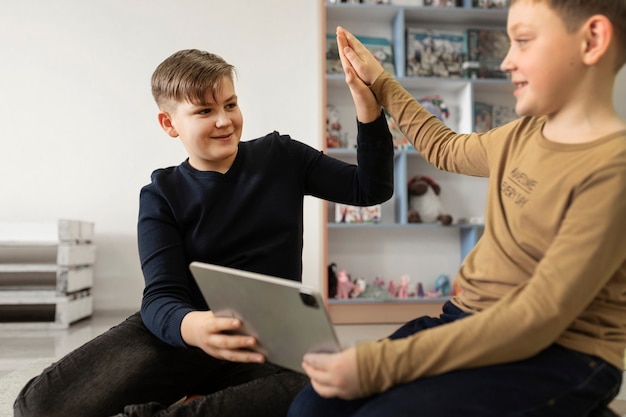 Zwei Jungs, die ein Tablet benutzen und zusammenarbeiten