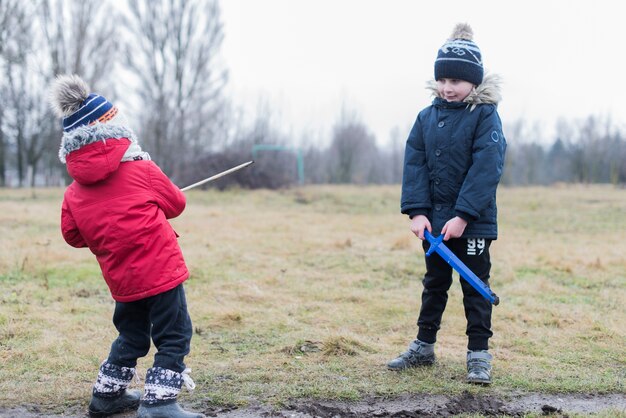 Zwei Kinder, die draußen mit Schlamm spielen