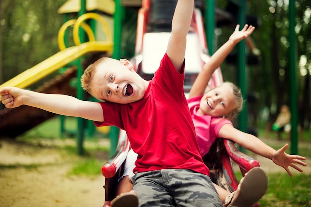 Kostenloses Foto zwei kinder rutschen auf dem spielplatz