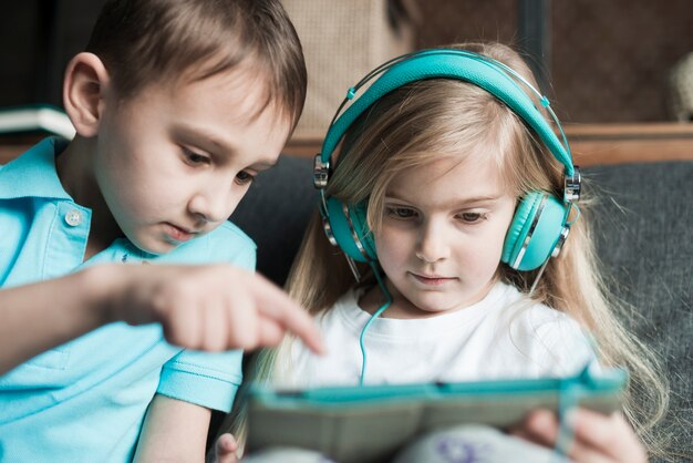 Zwei Kinder spielen mit Tablet