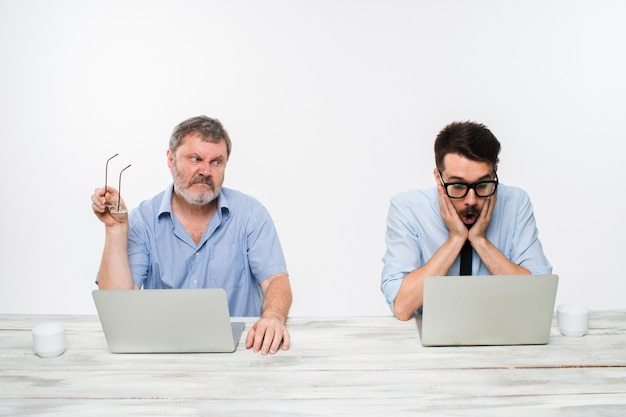 Kostenloses Foto zwei kollegen arbeiten im büro auf weiß zusammen