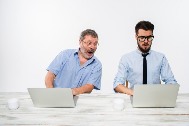 zwei Kollegen, die im Büro auf Weiß zusammenarbeiten