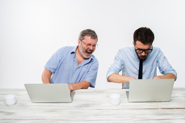 Kostenloses Foto zwei kollegen, die im büro auf weiß zusammenarbeiten