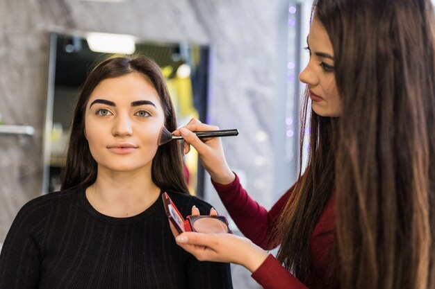 Zwei Mädchen arbeiten am abendlichen hellen Make-up