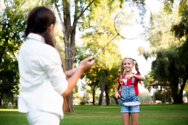 Zwei Mädchen, die Badminton am schönen Sommertag spielen
