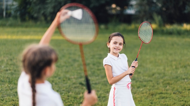 Zwei Mädchen, die Badminton im Park spielen