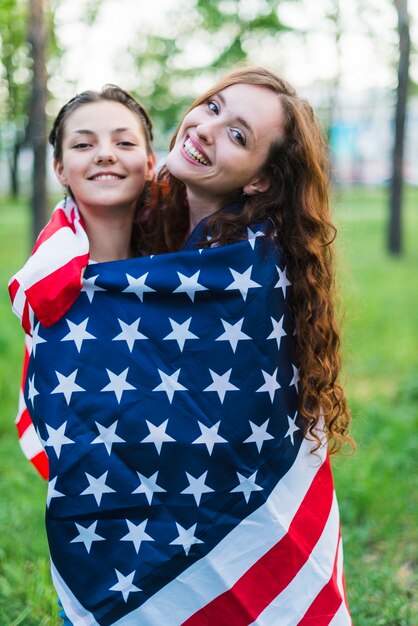 Zwei Mädchen in der Natur mit amerikanischer Flagge