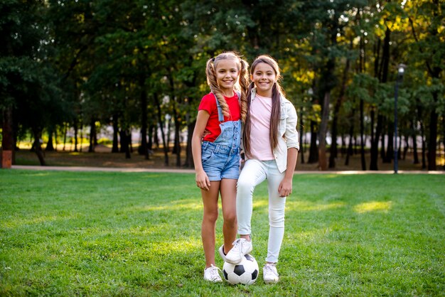 Zwei Mädchen mit der Fußballkugel im Freien