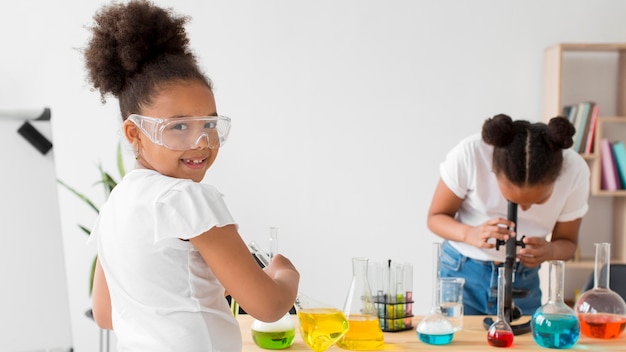 Zwei Mädchen mit Schutzbrille experimentieren mit Chemie und Tränken