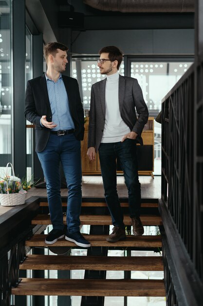 Kostenloses Foto zwei männer gehen die treppe hinunter und plaudern drinnen