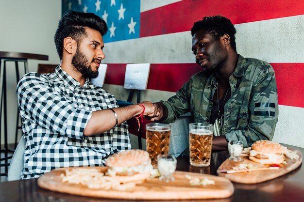 Zwei Männer sitzen zusammen in einer Bar oder Restaurantlounge. Geben Sie sich die Hände