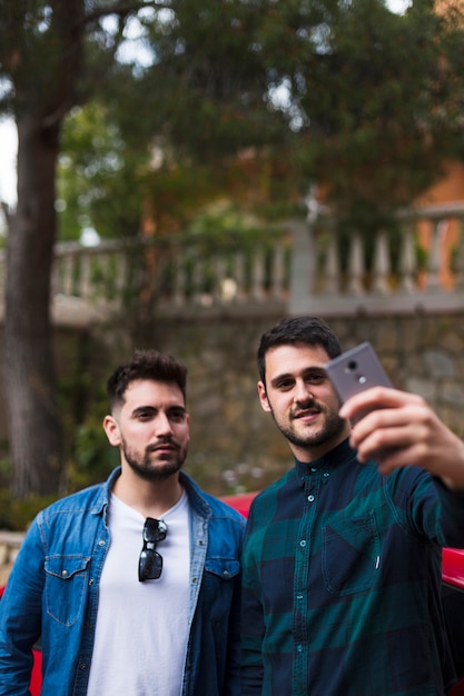 Zwei männliche Freunde, die selfie am Handy nehmen