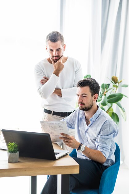 Zwei männliche Geschäftsmänner, die im Büro arbeiten