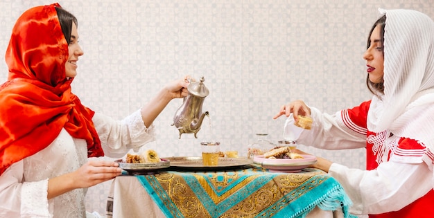 Zwei moslemische Frauen, die am Tisch sitzen