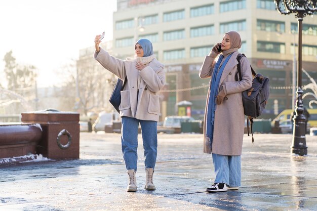 Zwei muslimische Frauen machen auf Reisen ein Selfie
