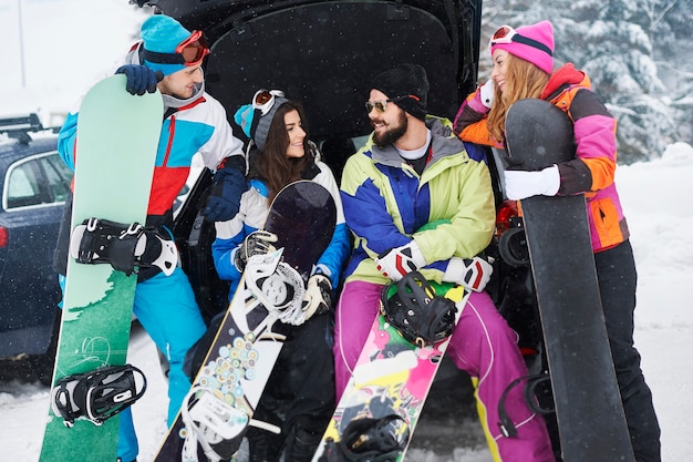 Zwei Paare, die Spaß haben und snowboarden