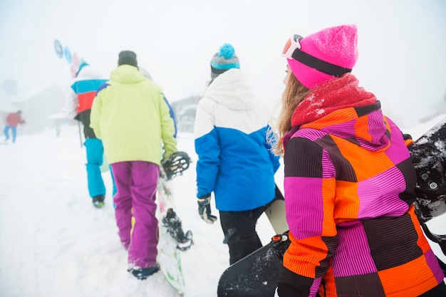 Zwei Paare, die Spaß haben und snowboarden