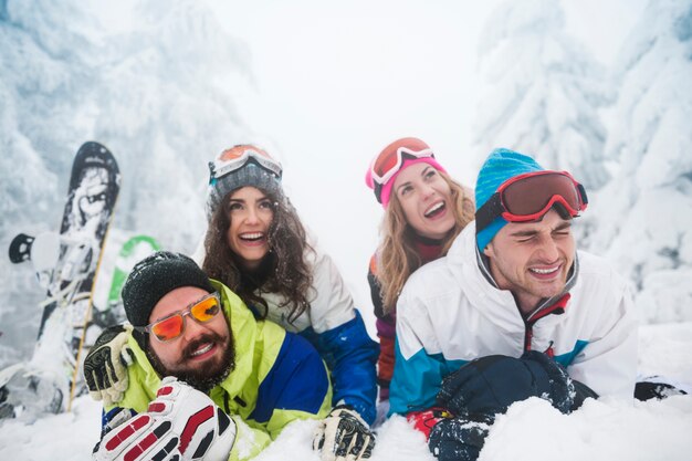 Zwei Paare, die Spaß haben und snowboarden