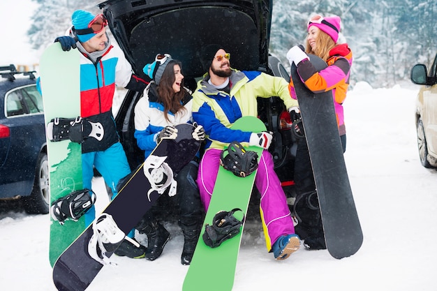 Zwei Paare, die Spaß haben und snowboarden