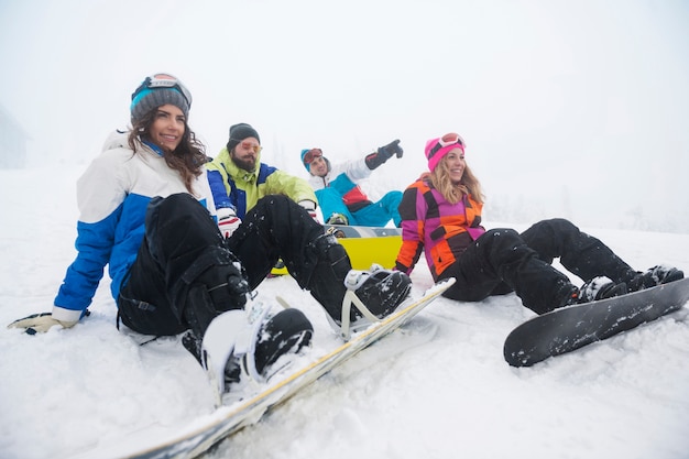 Zwei Paare, die Spaß haben und snowboarden