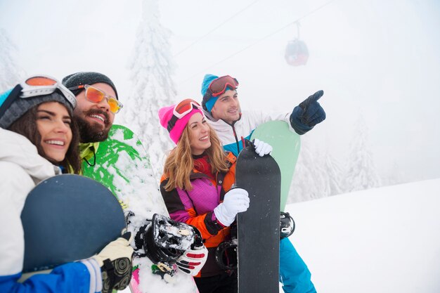 Zwei Paare, die Spaß haben und snowboarden