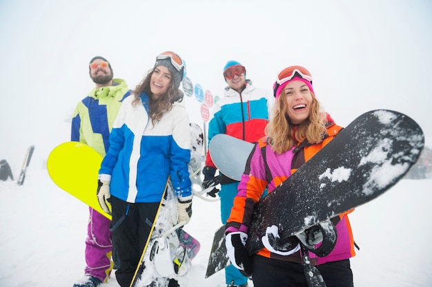 Zwei Paare, die Spaß haben und snowboarden