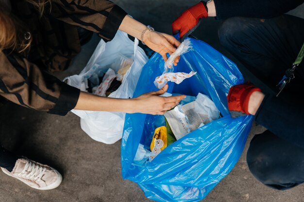 Zwei Personen sortieren Müll. Konzept des Recyclings. Kein Verlust