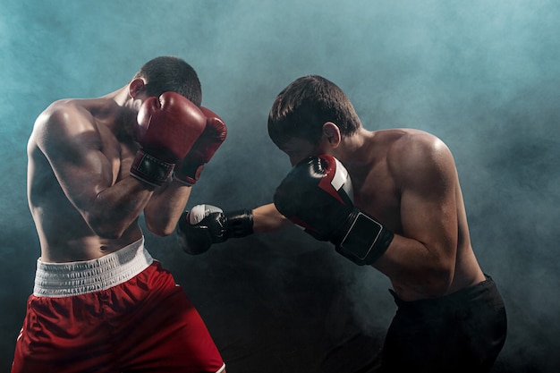 Zwei professionelle Boxerboxen auf schwarzem Rauch