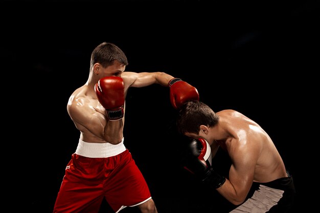Zwei professionelle Boxerboxen auf schwarzem rauchigem Hintergrund,