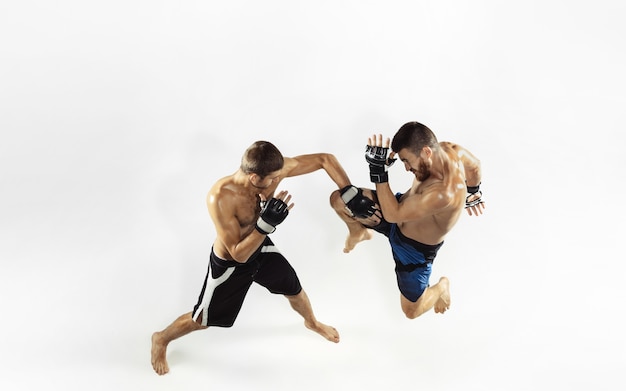 Zwei professionelle MMA-Kämpfer, die auf weißem Studio isoliert boxen.