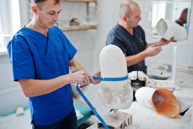 Kostenloses Foto zwei prothetische arbeiter stellen bei der arbeit im labor beinprothesen her