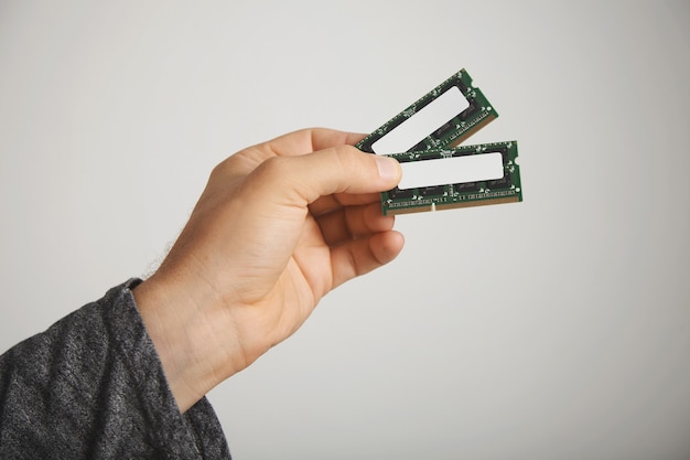 Kostenloses Foto zwei ram-chips in der hand eines mannes isoliert auf weiß