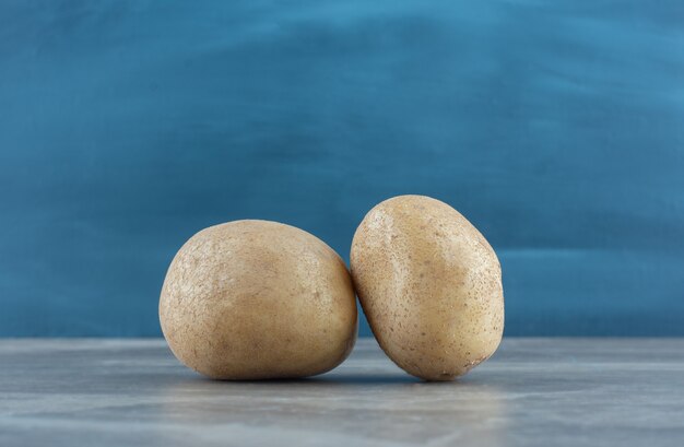 Zwei reife Kartoffeln, auf dem Marmortisch.