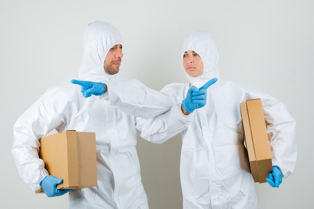 Zwei Ärzte in Schutzanzügen, Handschuhe mit Pappkartons