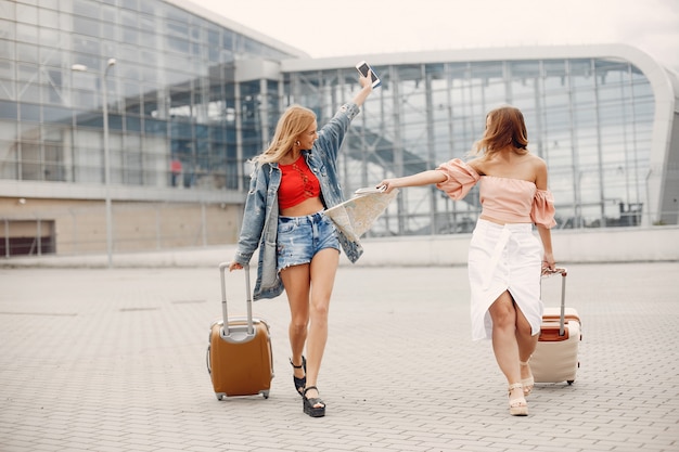 Zwei schöne Mädchen, die den Flughafen bereitstehen