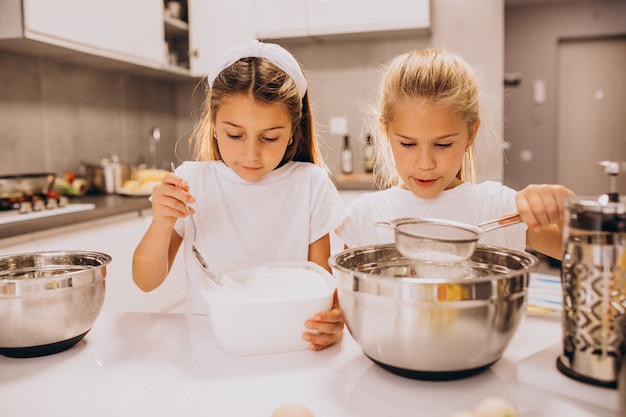 Zwei Schwestern der kleinen Mädchen, die an der Küche kochen