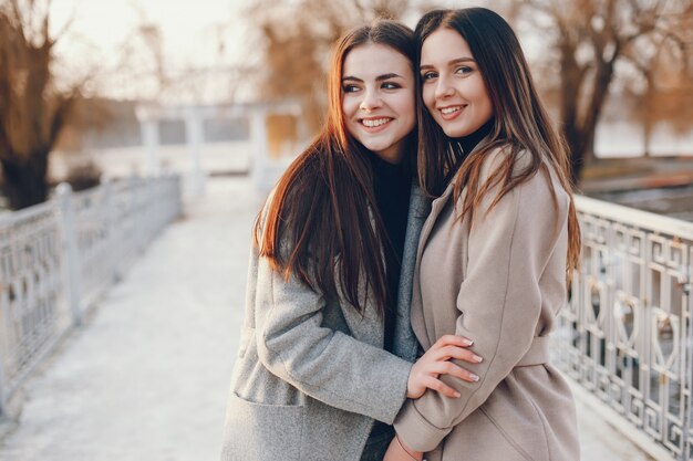 Zwei stilvolle Mädchen erholen sich in einer Stadt