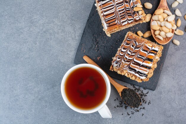 Zwei Stück Kuchen auf dunklem Schneidebrett.