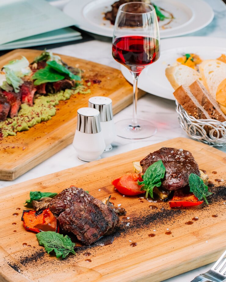 Kostenlose Foto zwei stücke mittelgekochtes steak, serviert mit tomatenpilz und zucchini